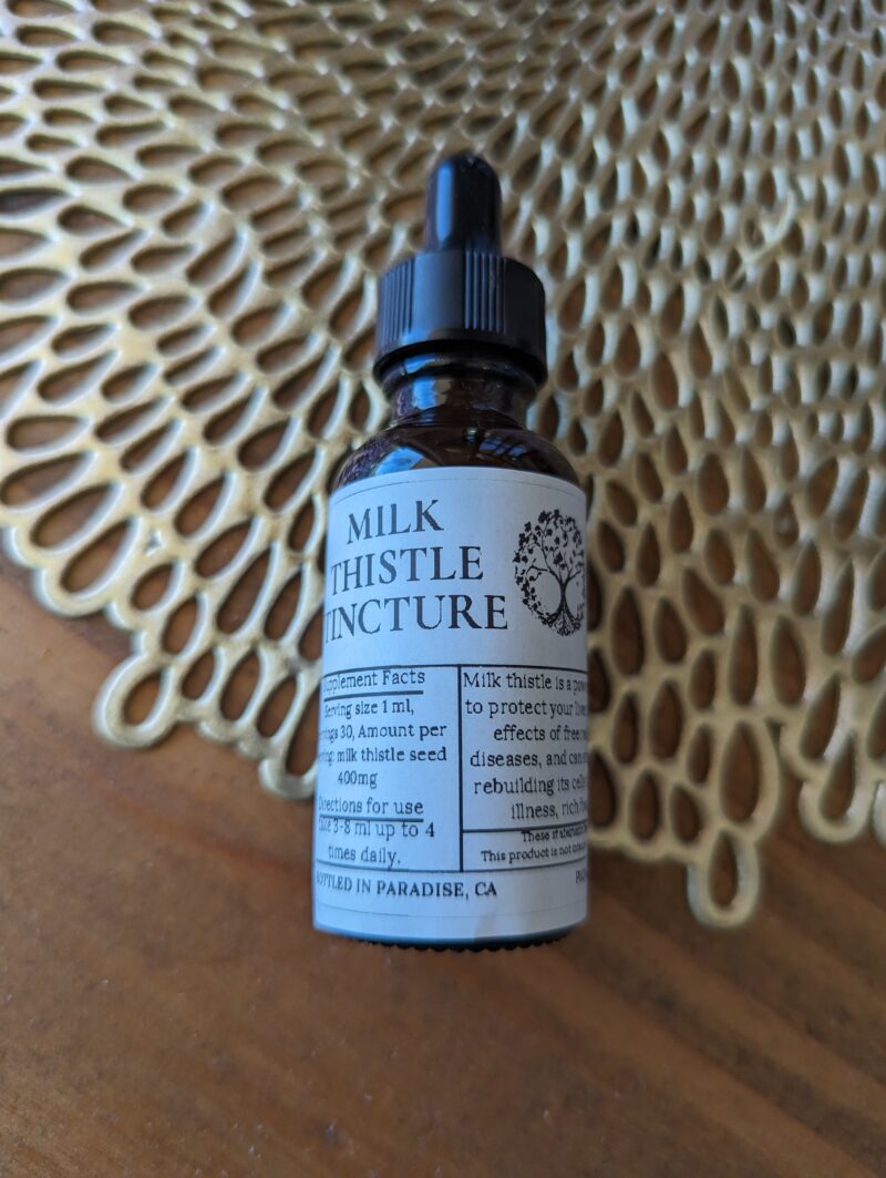 Milk Thistle tincture on gold and wood counter